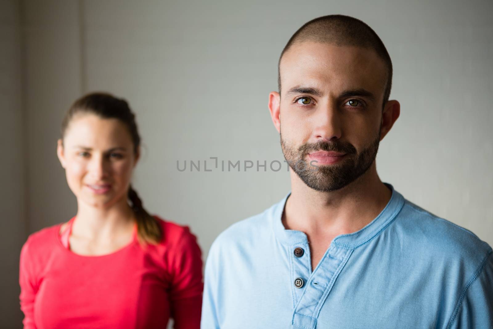 Portrait of yoga instructor with student standing in yoga studio