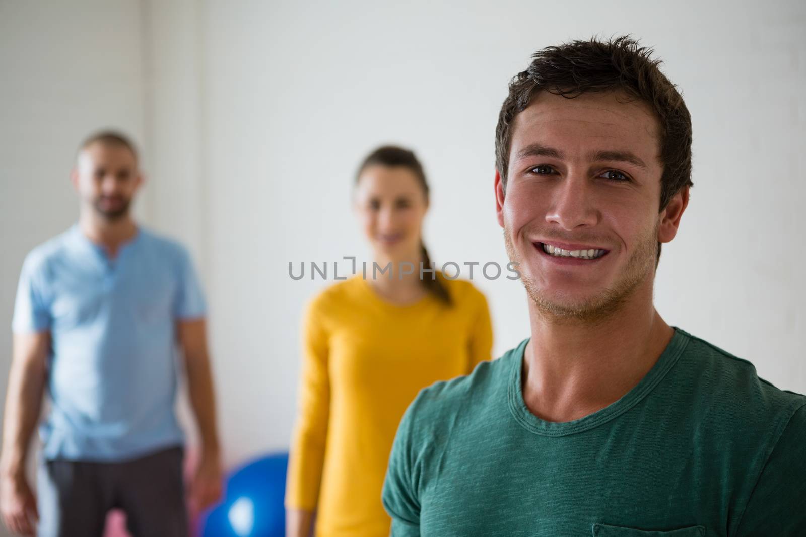 Portrait of man with yoga instructor and woman in club by Wavebreakmedia