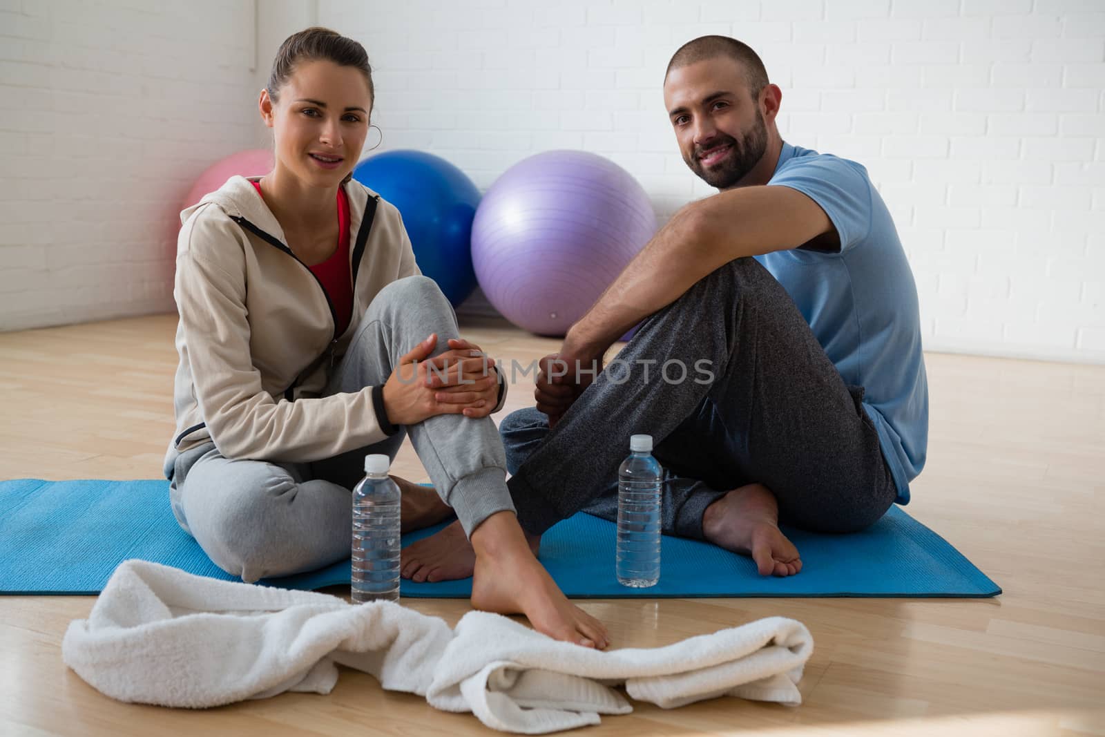Portrait of student with instructor relaxing in yoga studio by Wavebreakmedia