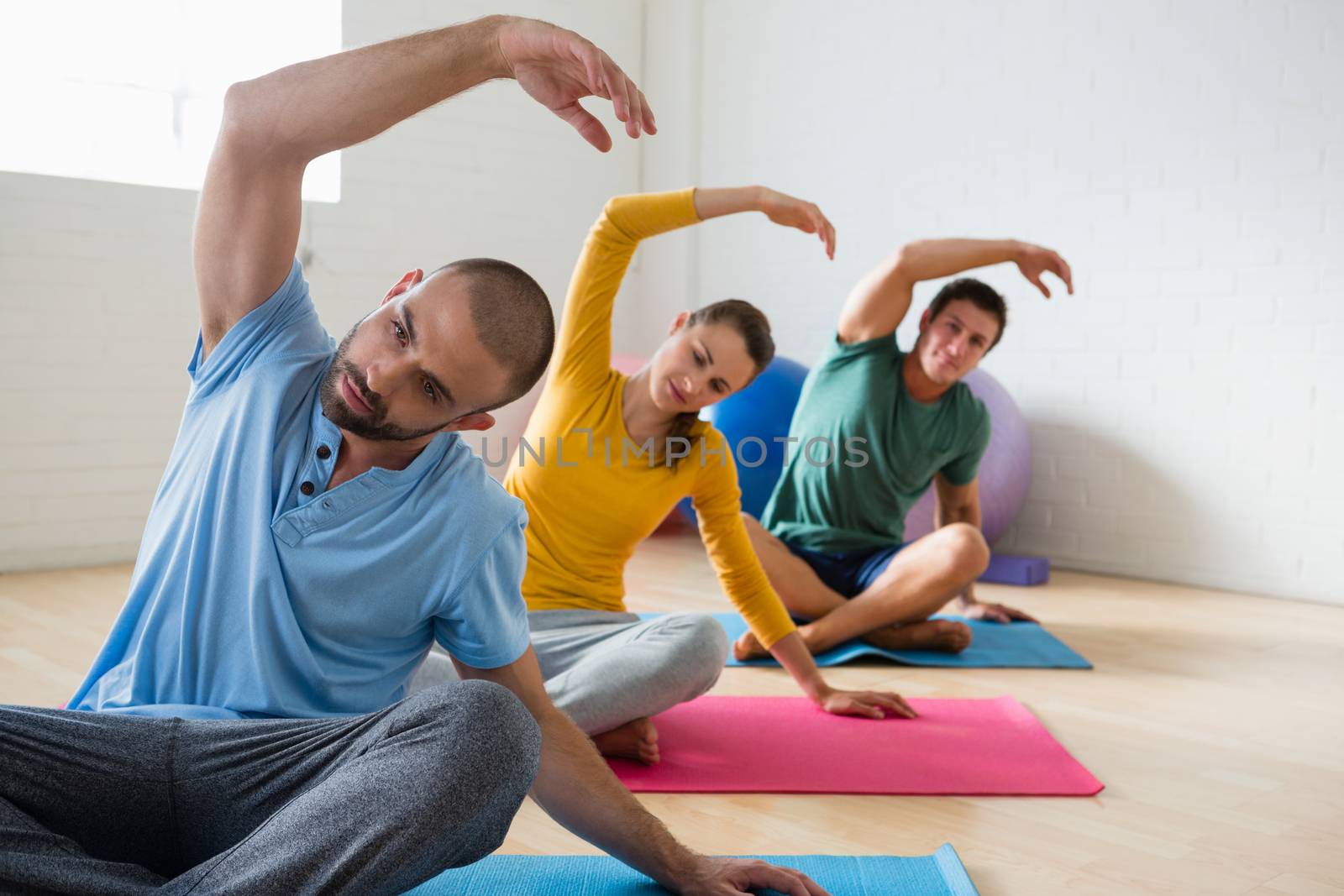 Yoga instructor with students exercising at health club 
