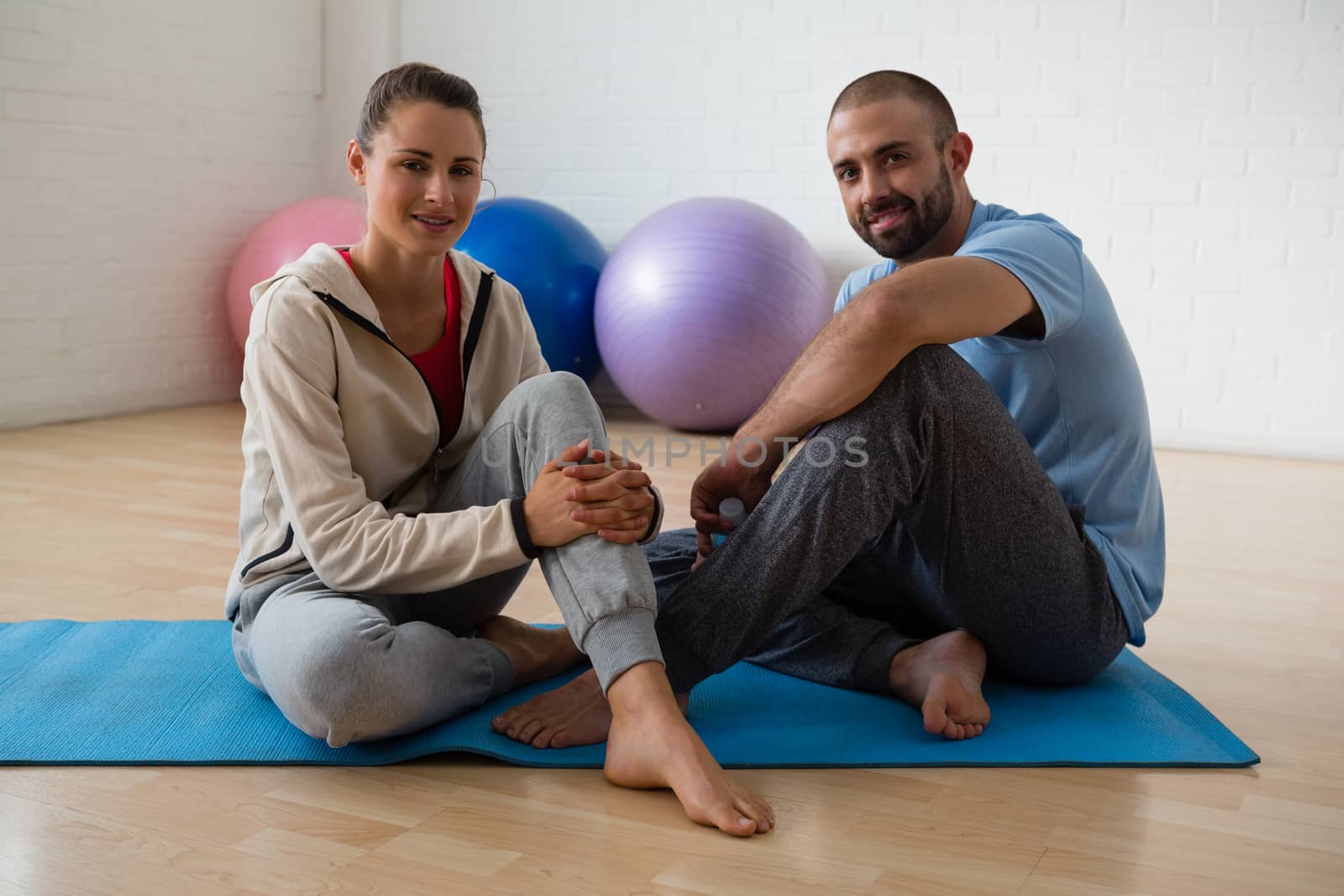 Portrait of student and yoga instructor relaxing in health club by Wavebreakmedia