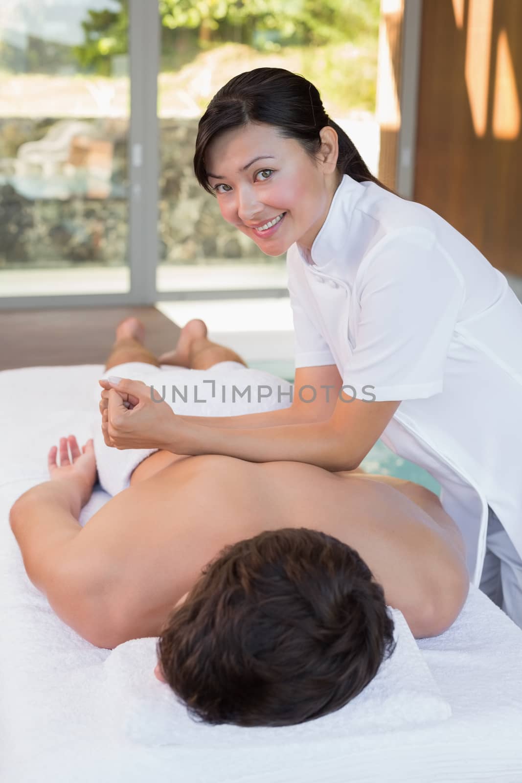 View of a young man receiving back massage at spa center