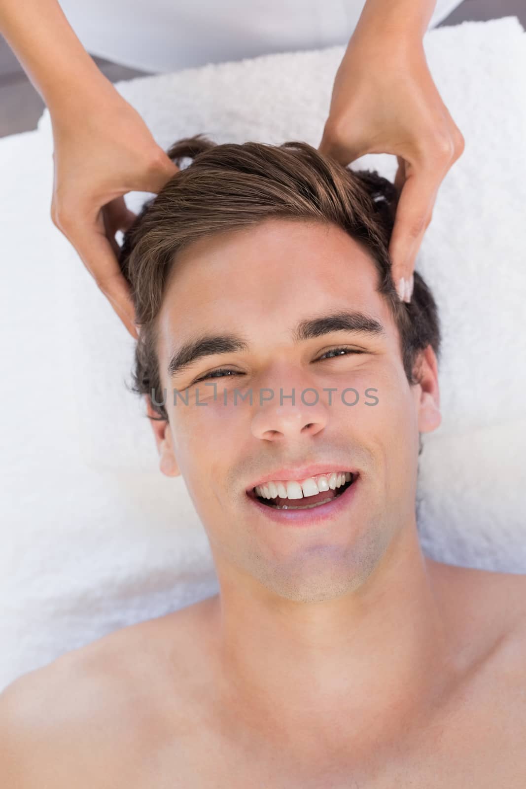 Close -up of a handsome young man receiving head massage at spa center