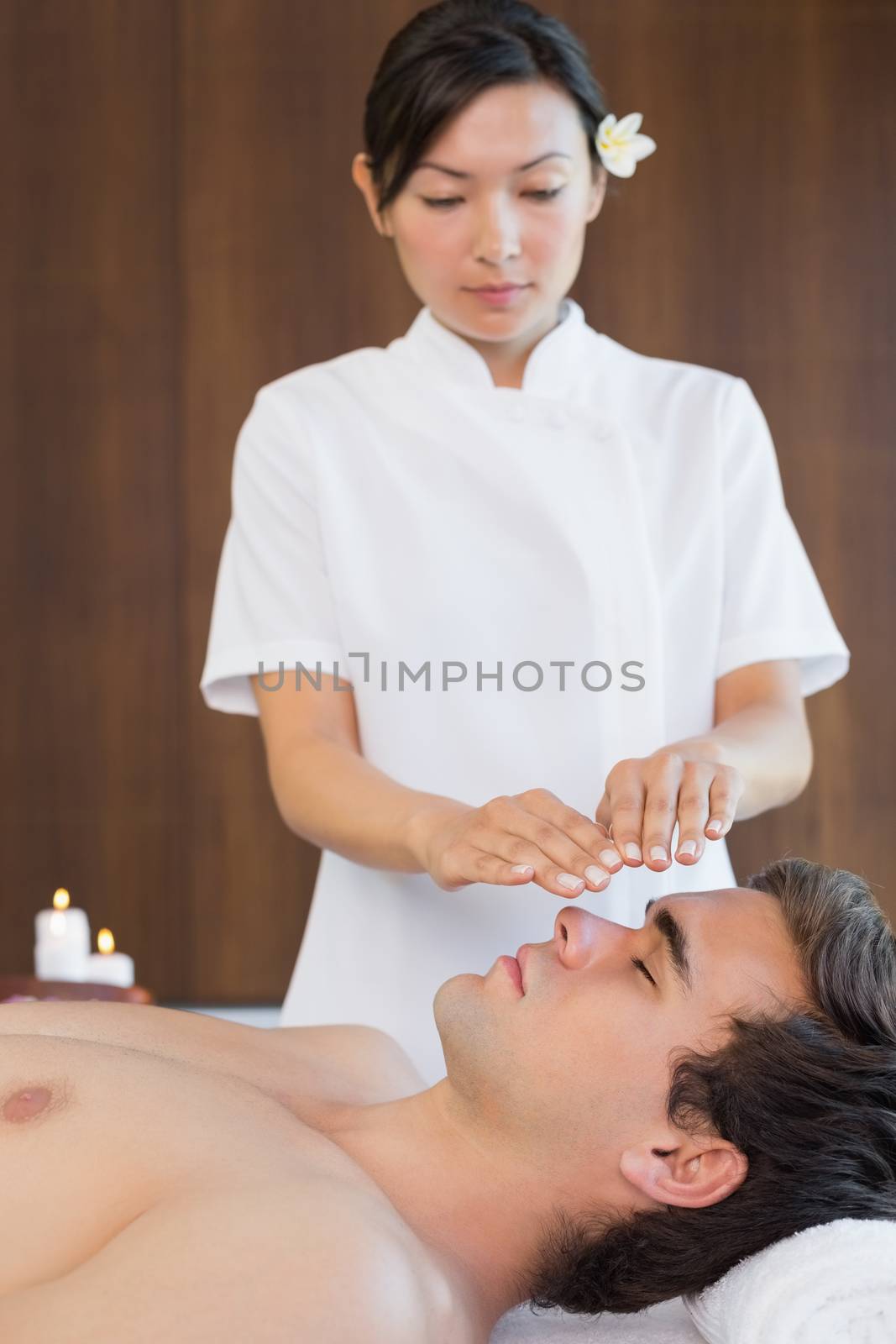 Man receiving treatment at spa center by Wavebreakmedia