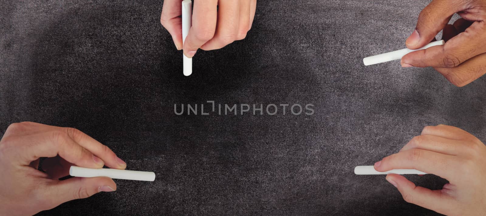 Composite image of cropped hands of people holding chalks by Wavebreakmedia