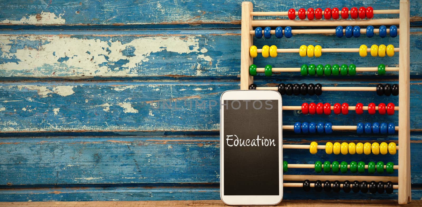 Education text against white background against smart phone with abacus on table
