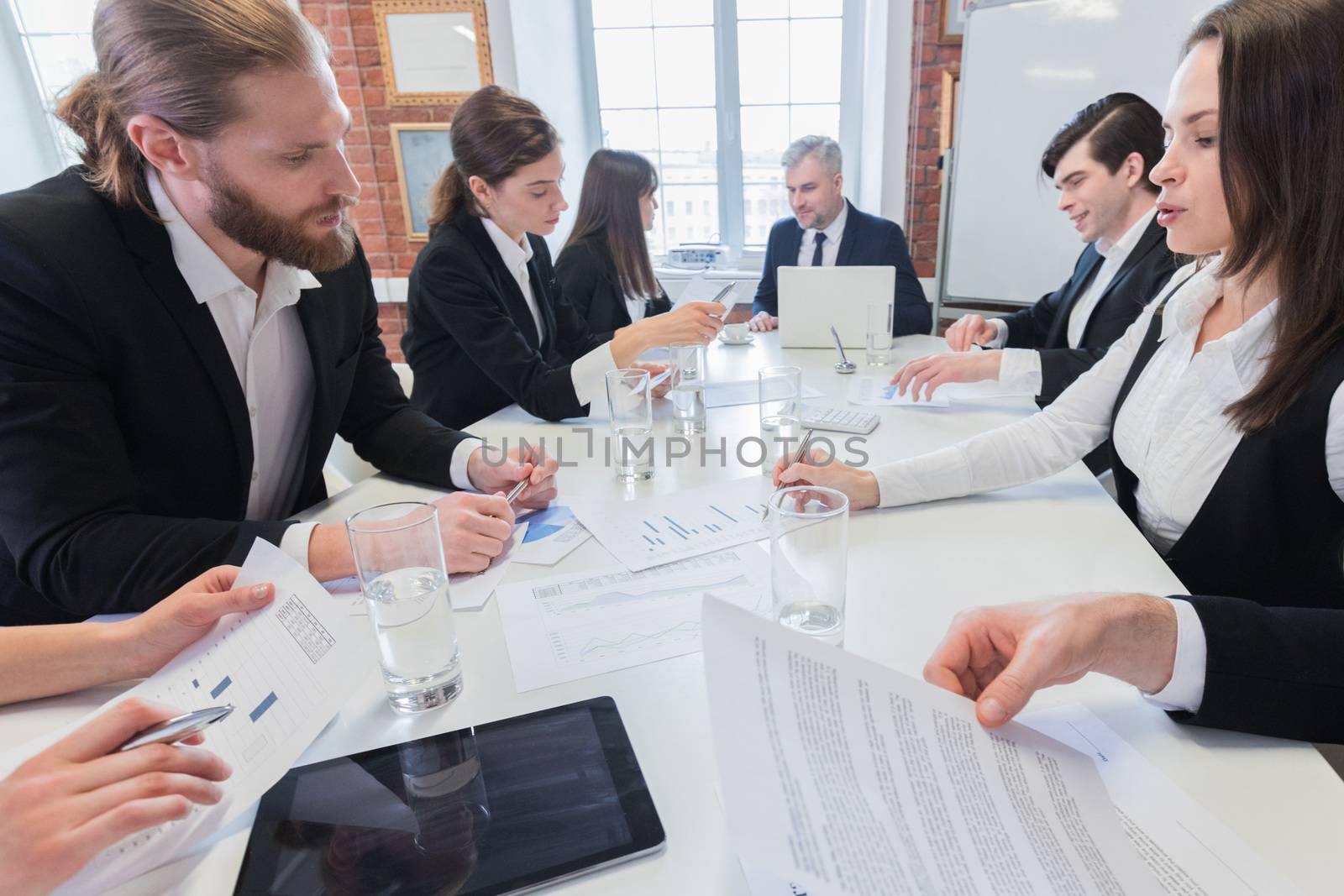 Group of many business people working together in office with financial reports