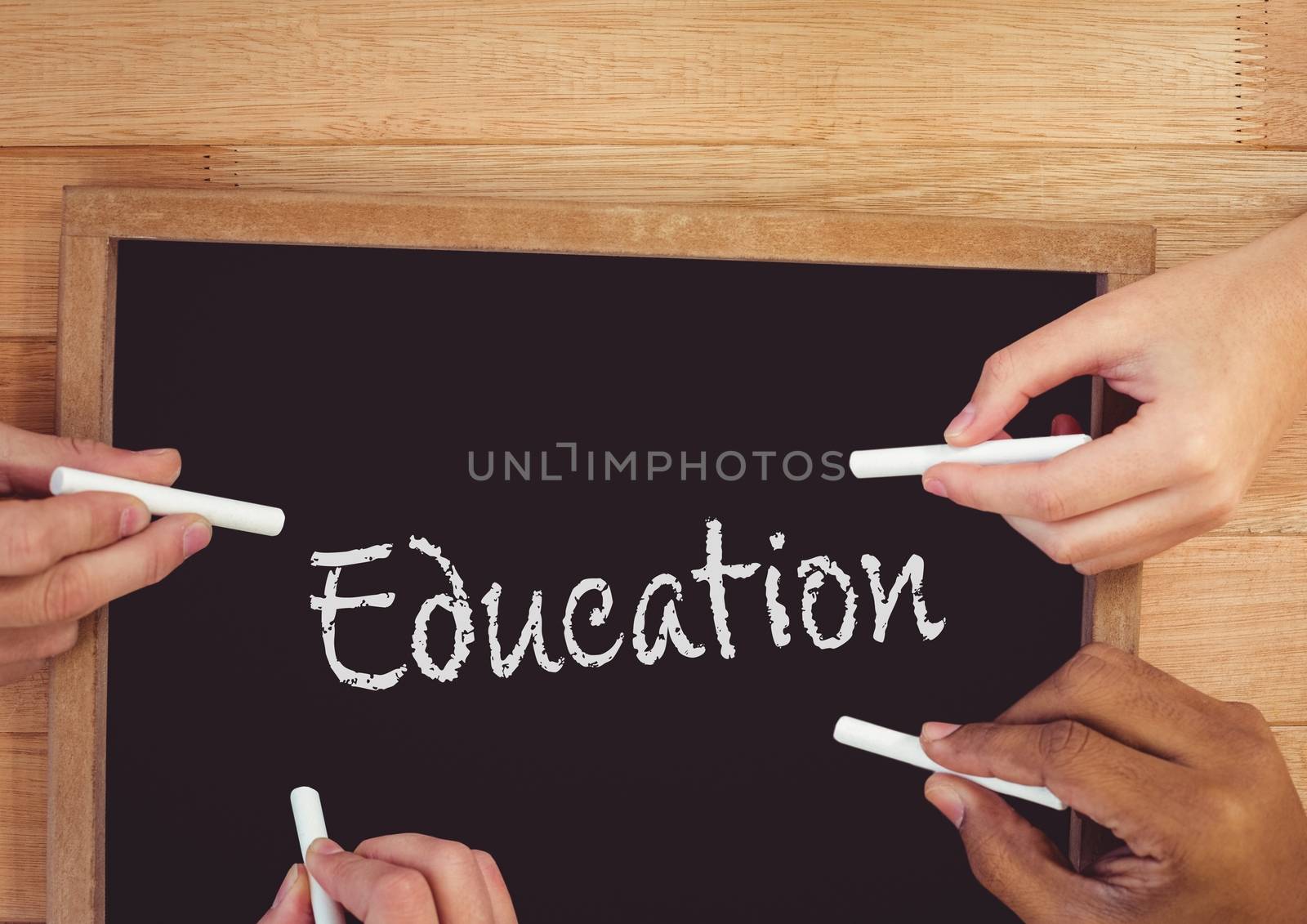 Hands writing education on blackboard by Wavebreakmedia