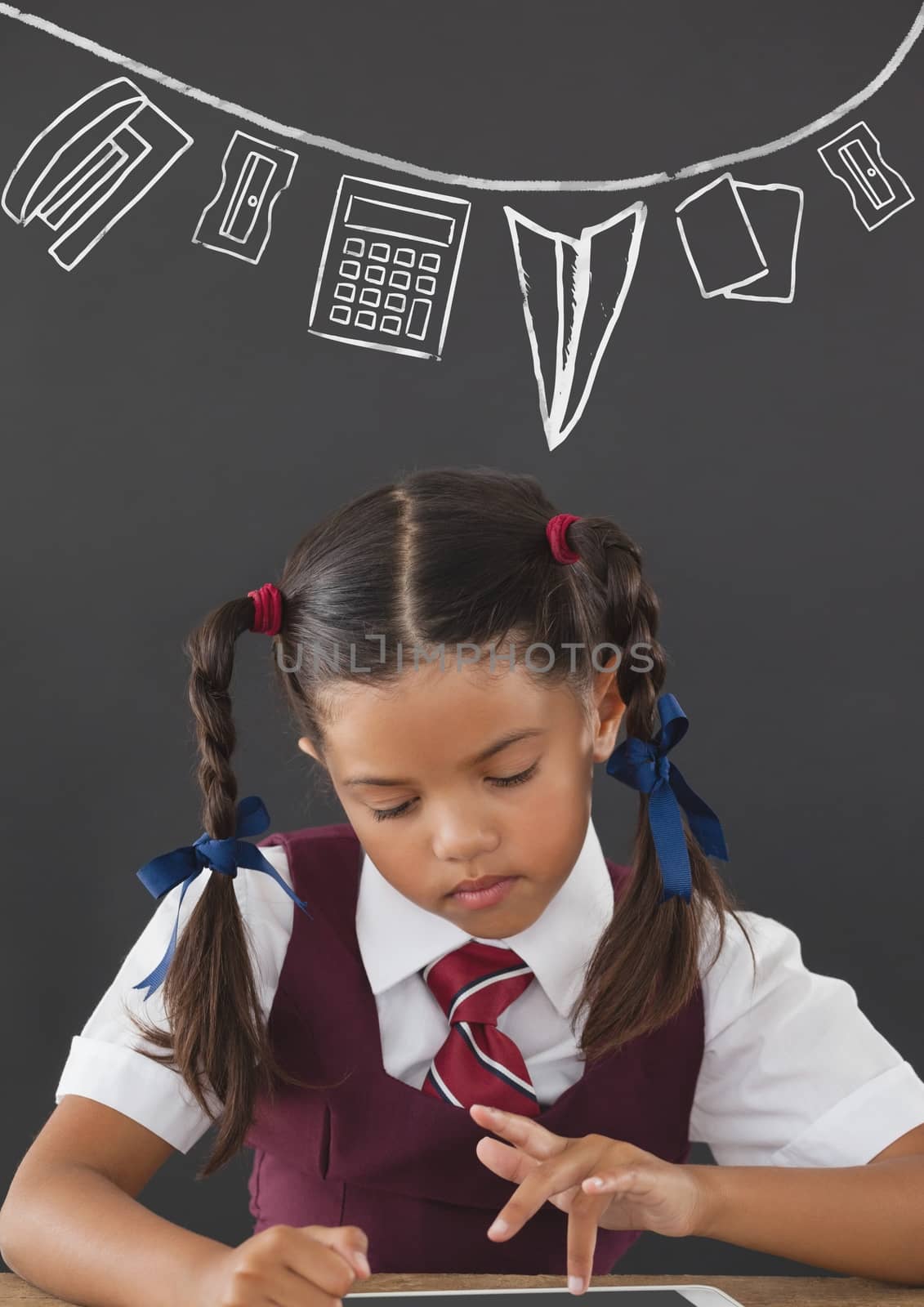 Student girl at table reading against grey blackboard with school and education graphic by Wavebreakmedia