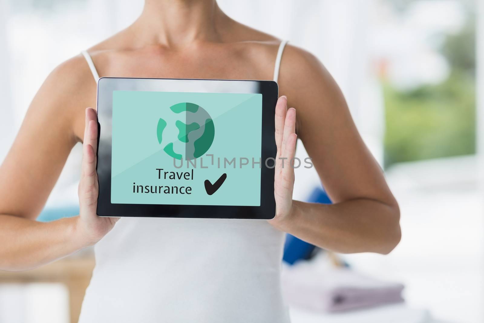 Woman holding a tablet with travel insurance concept on screen by Wavebreakmedia