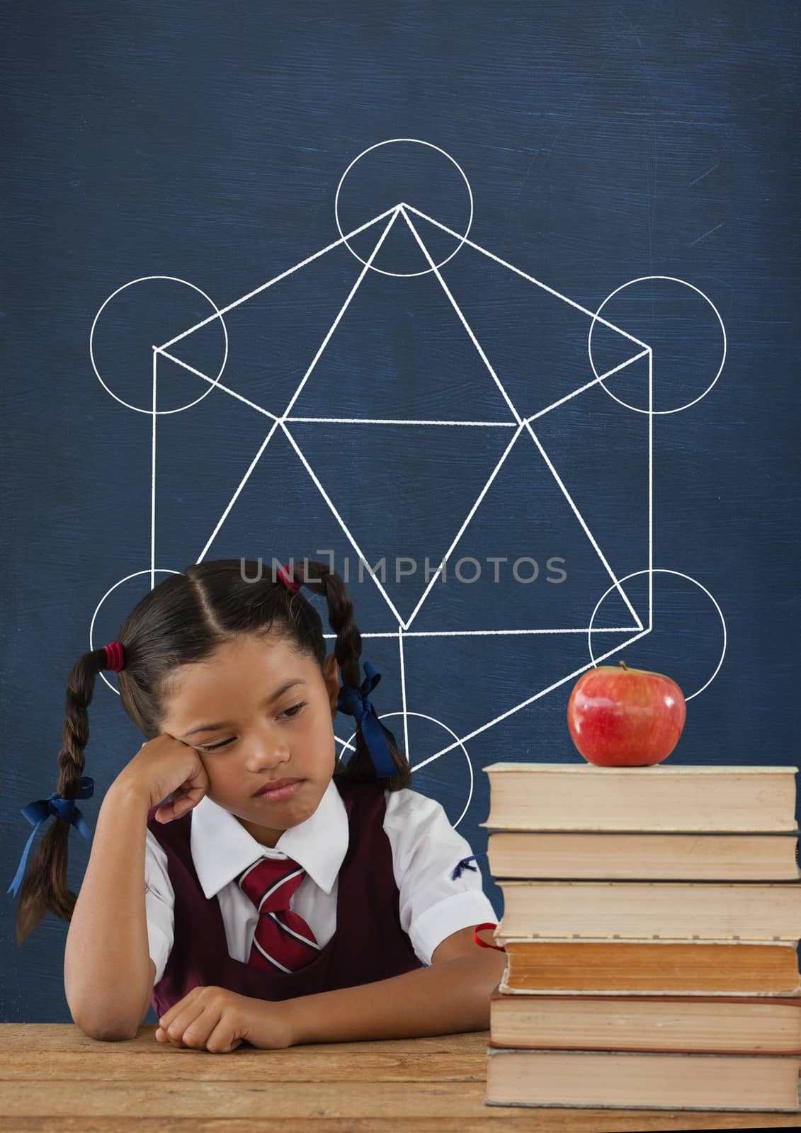 Digital composite of Sad student girl at table against blue blackboard with school and education graphic