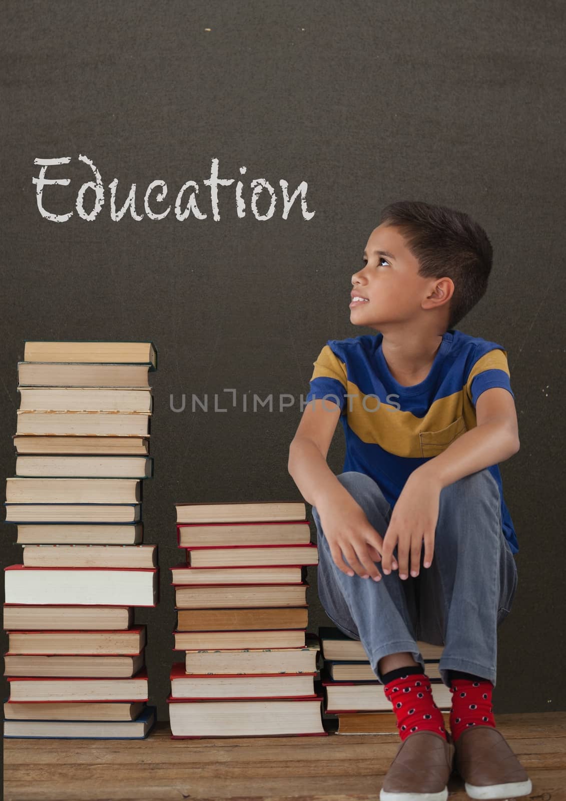 Digital composite of Student boy sitting on table against grey blackboard with education text