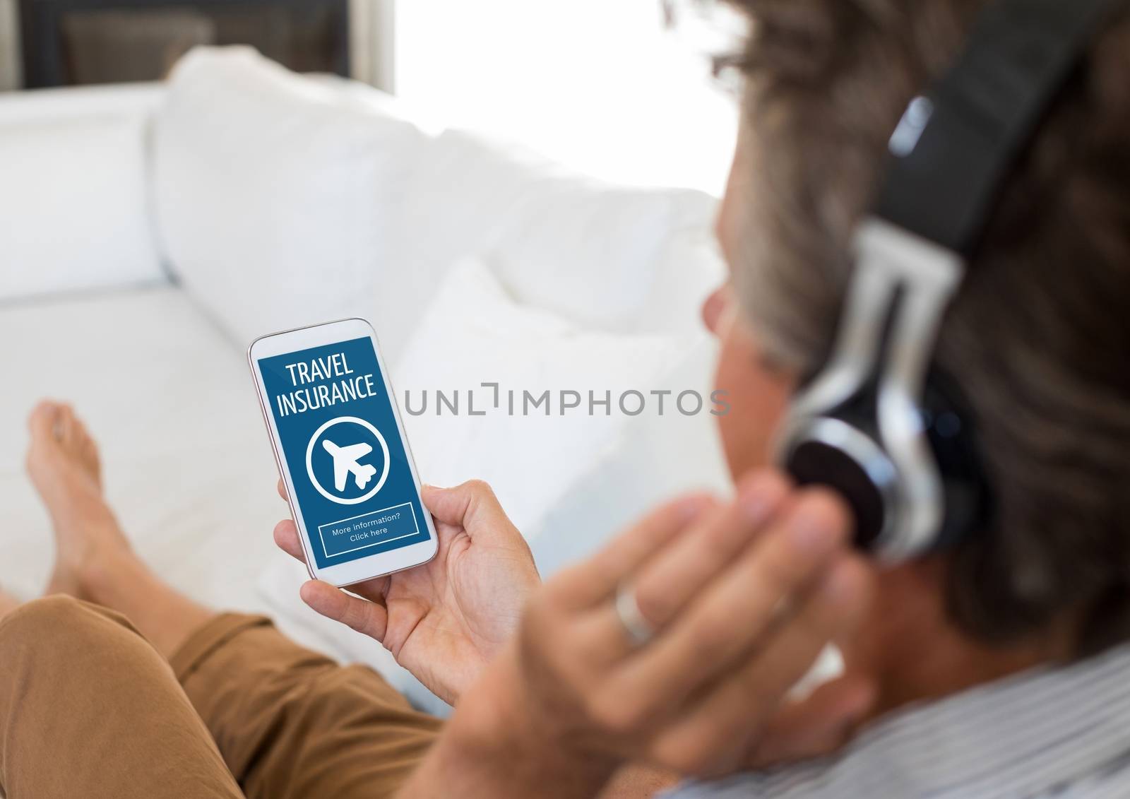 Man using a phone with travel insurance concept on screen by Wavebreakmedia