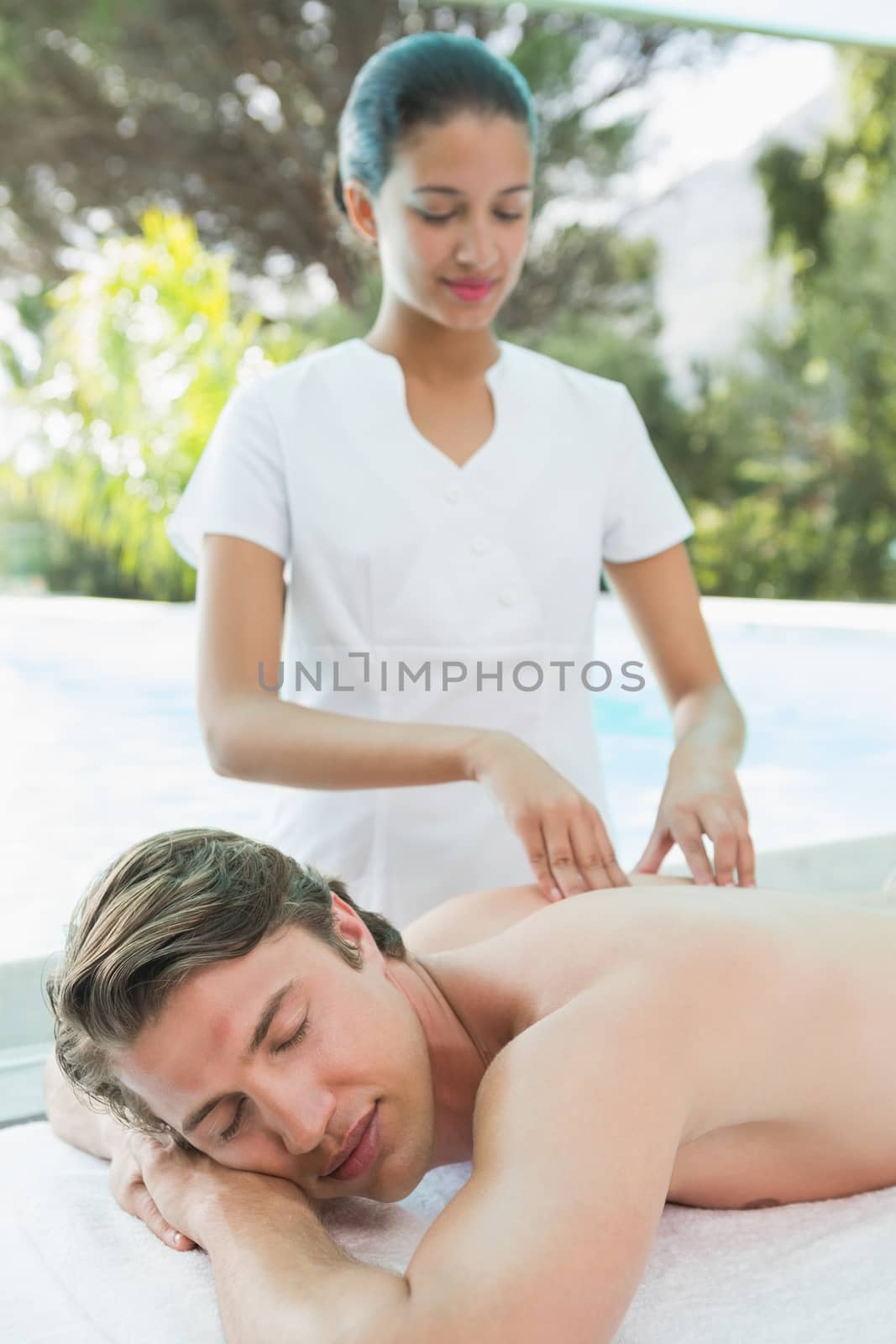 Handsome man receiving back massage at spa center by Wavebreakmedia