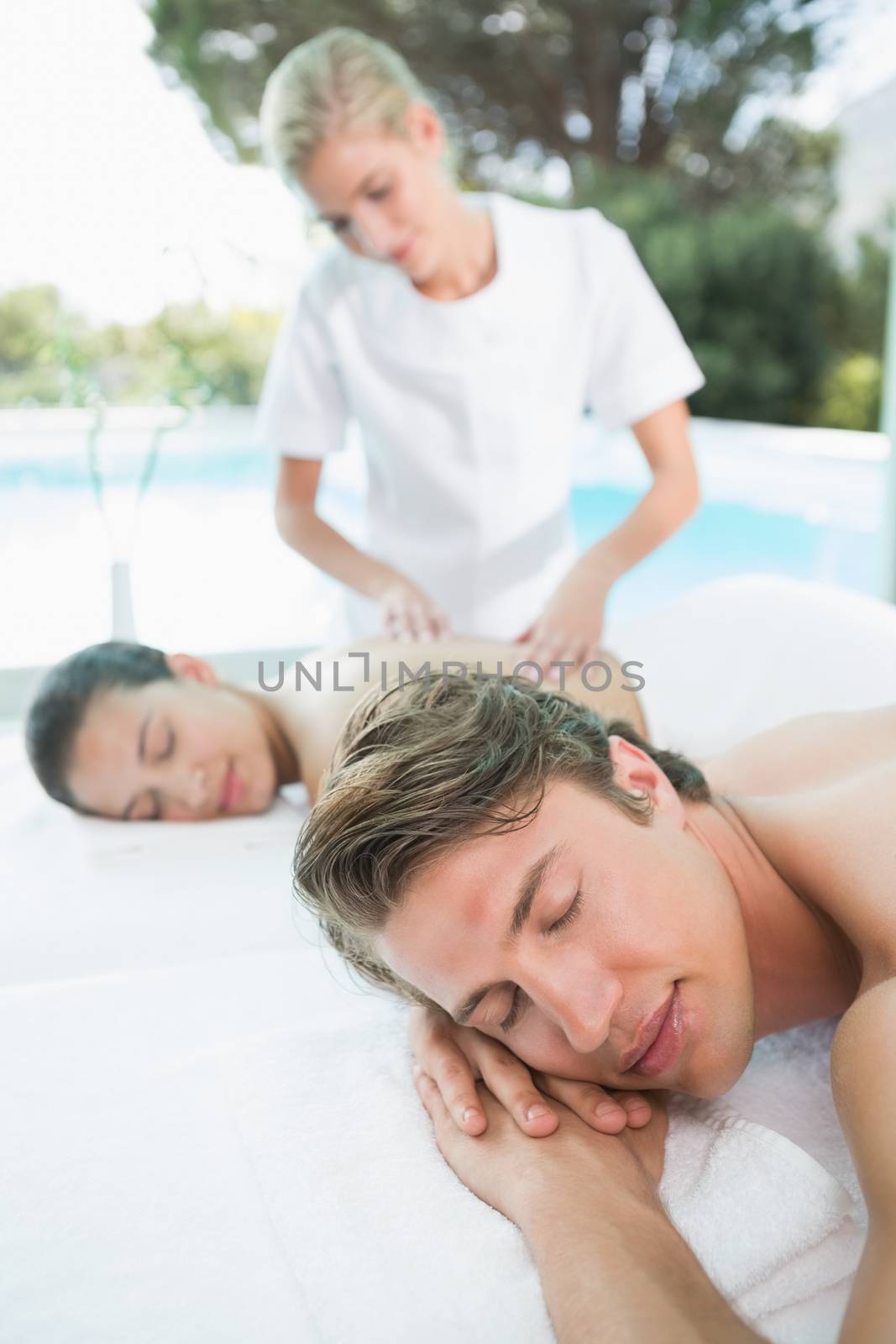 Side view of a young couple enjoying massage at health farm