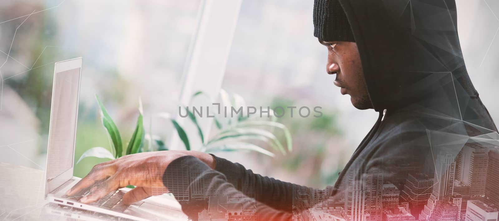 Male hacker using laptop  against abstract glowing black background