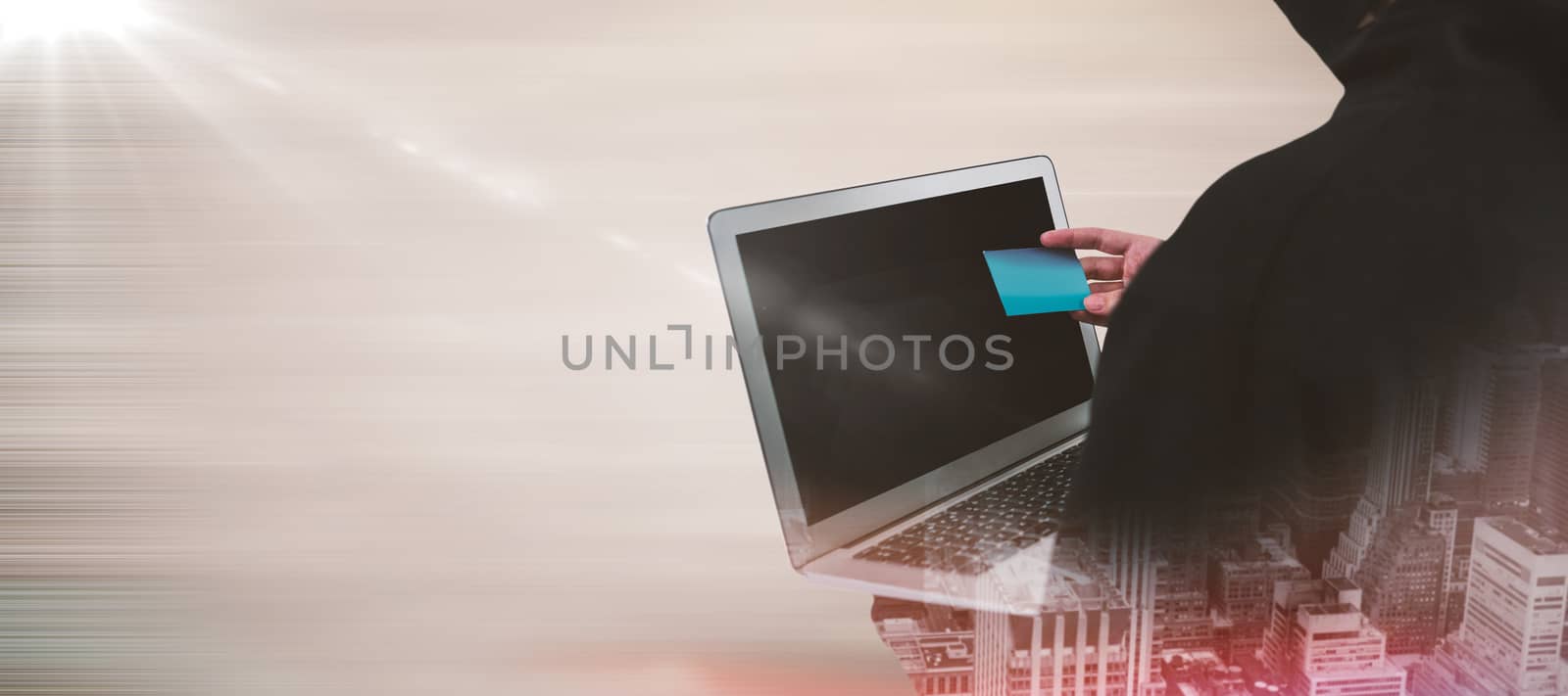 Rear view of hacker using laptop and credit card against brown abstract image