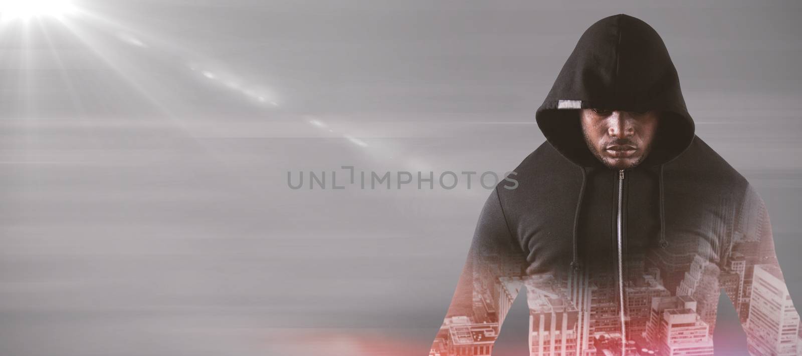 Male robber in black hoodie standing  against gray abstract image
