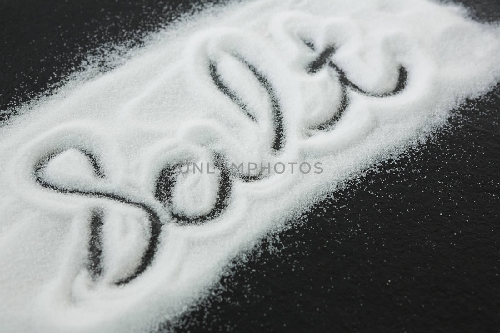 Word Salt on black background written by spilled salt by Wavebreakmedia