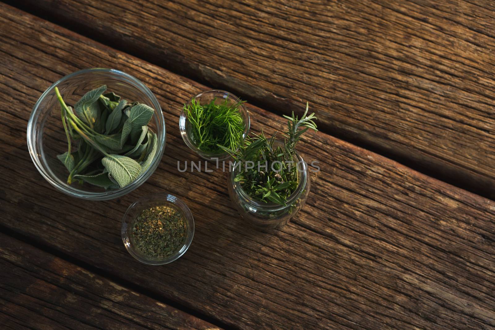 Various herbs in a jar on wooden table by Wavebreakmedia