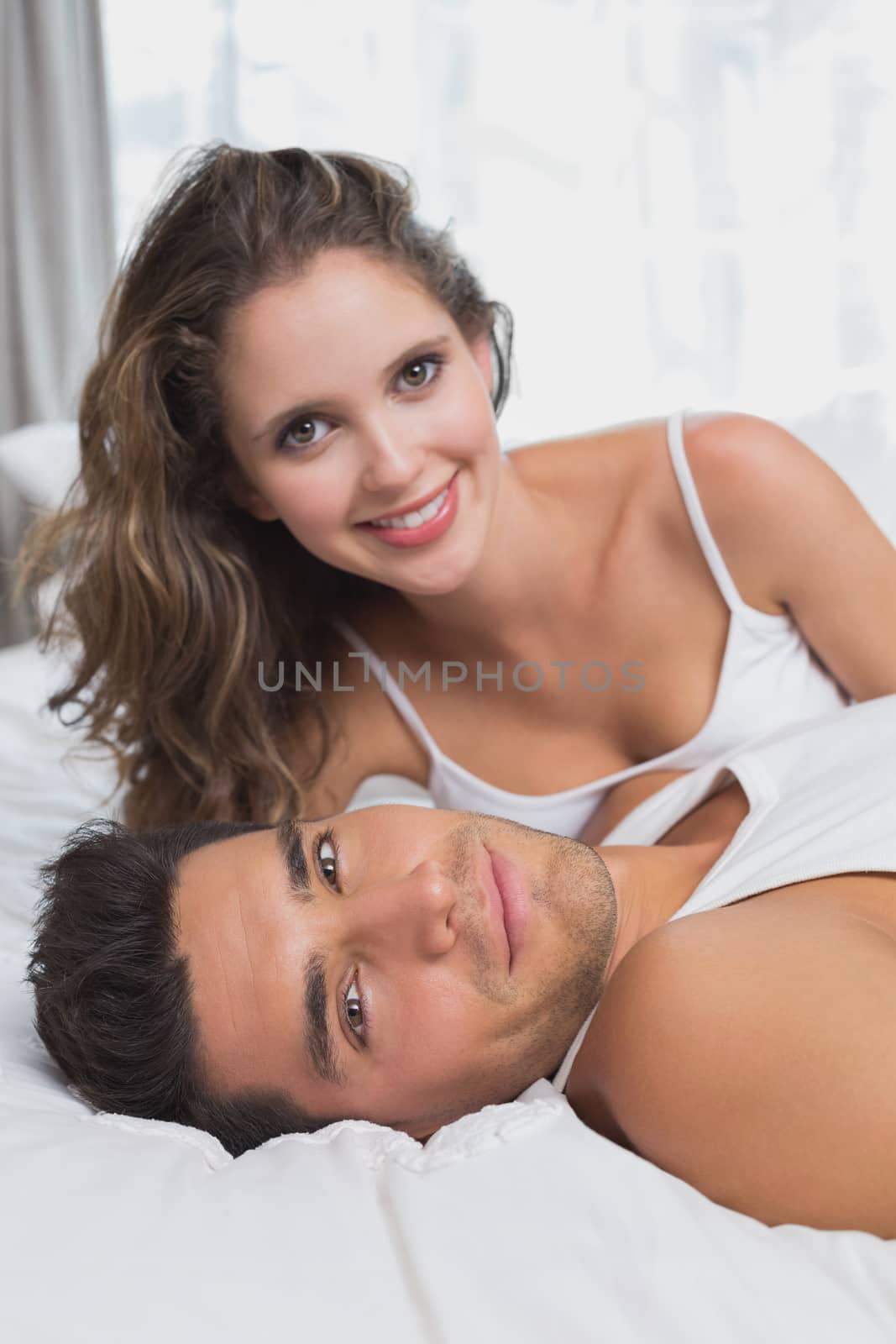 Couple lying in bed at home by Wavebreakmedia