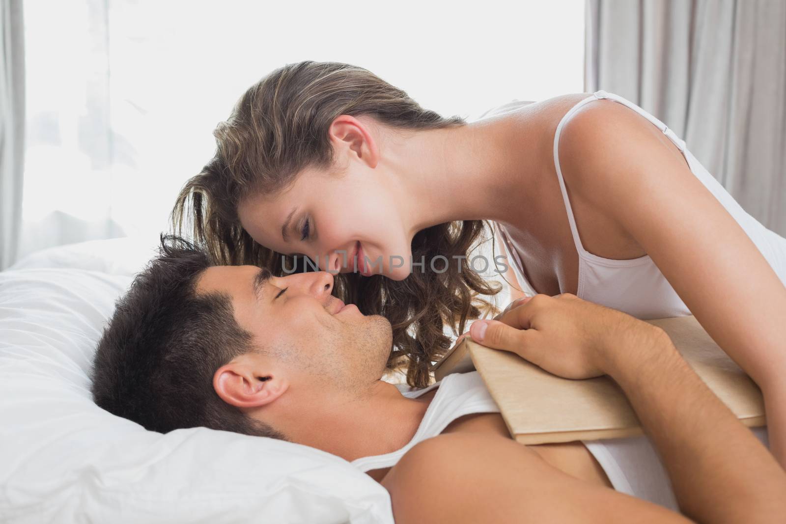 Romantic couple in bed at home by Wavebreakmedia