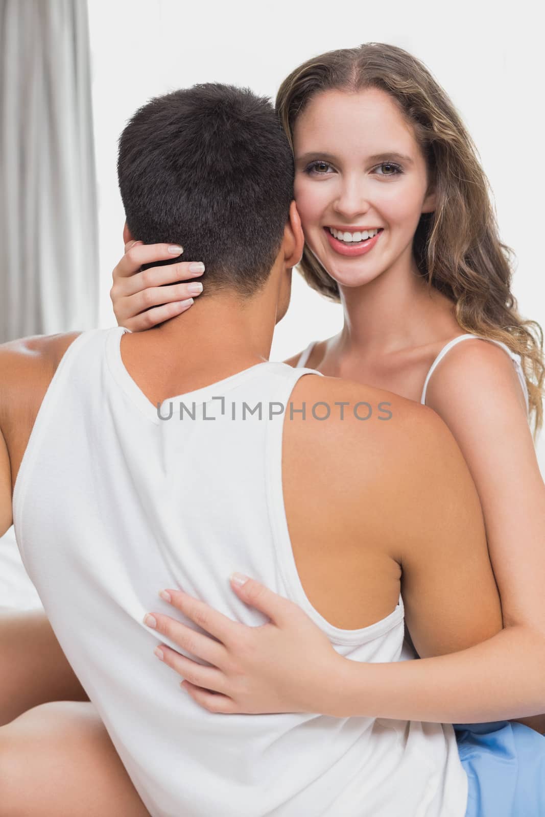 Loving relaxed young couple together in bed at home
