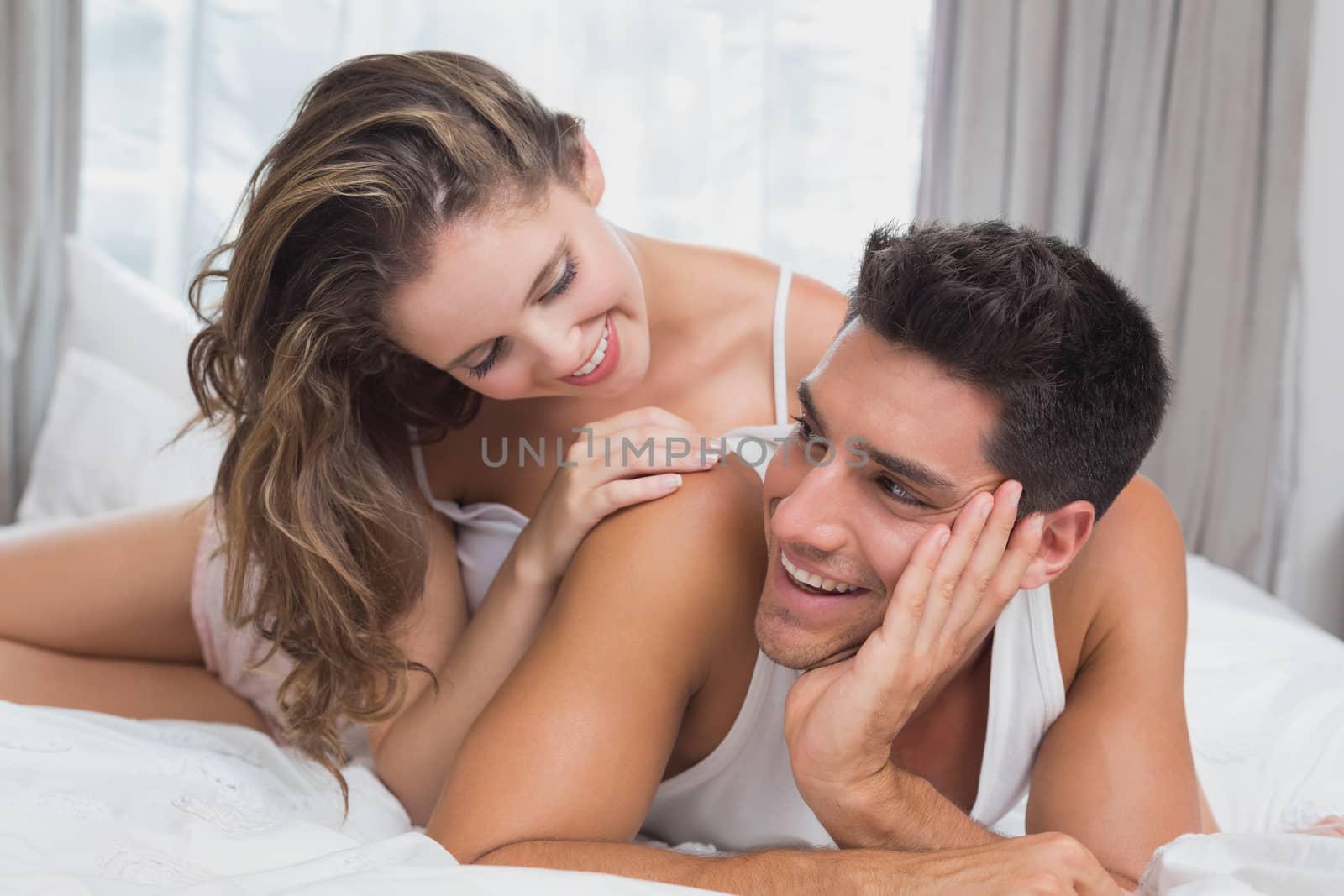 Close up portrait of romantic young couple in bed at home