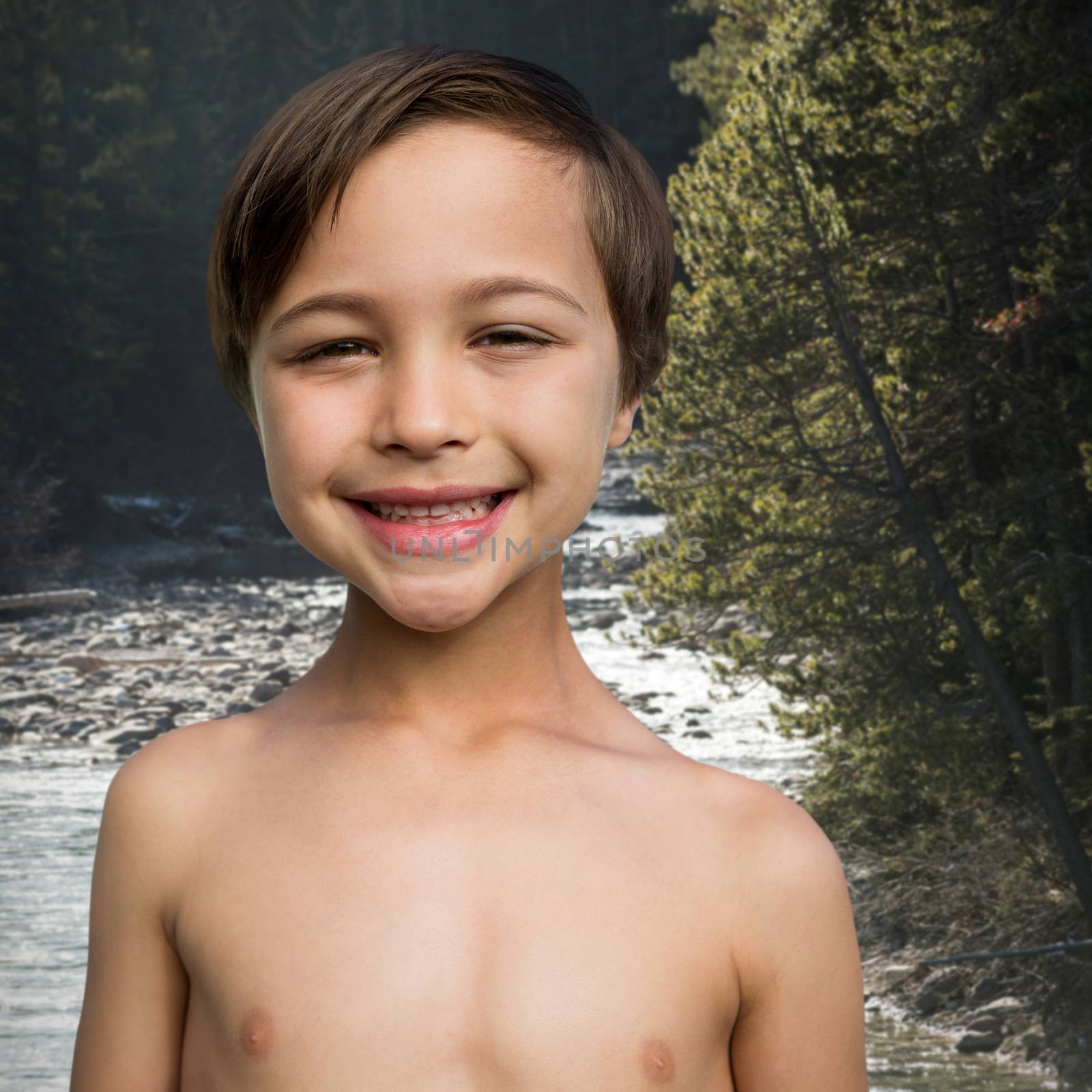 Close up of cheerful shirtless boy against river flowing through forest