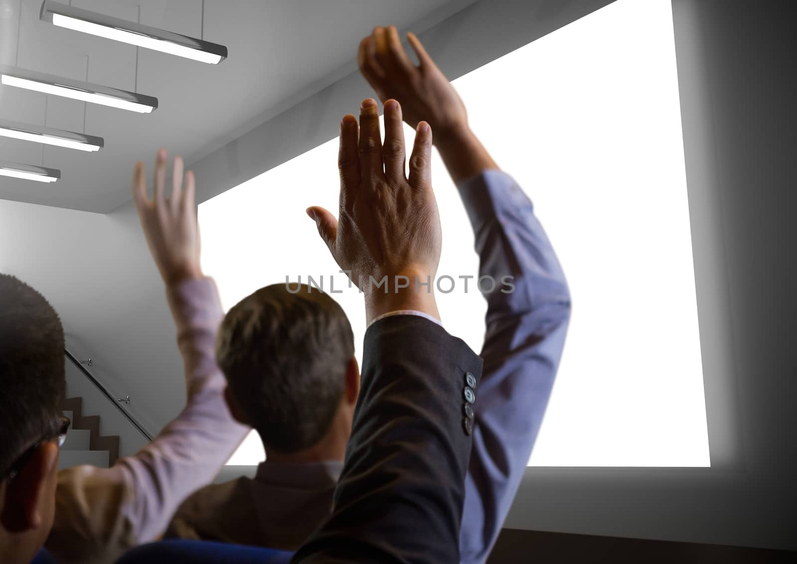 Digital composite of Business people with hands raised up in front of conference screen