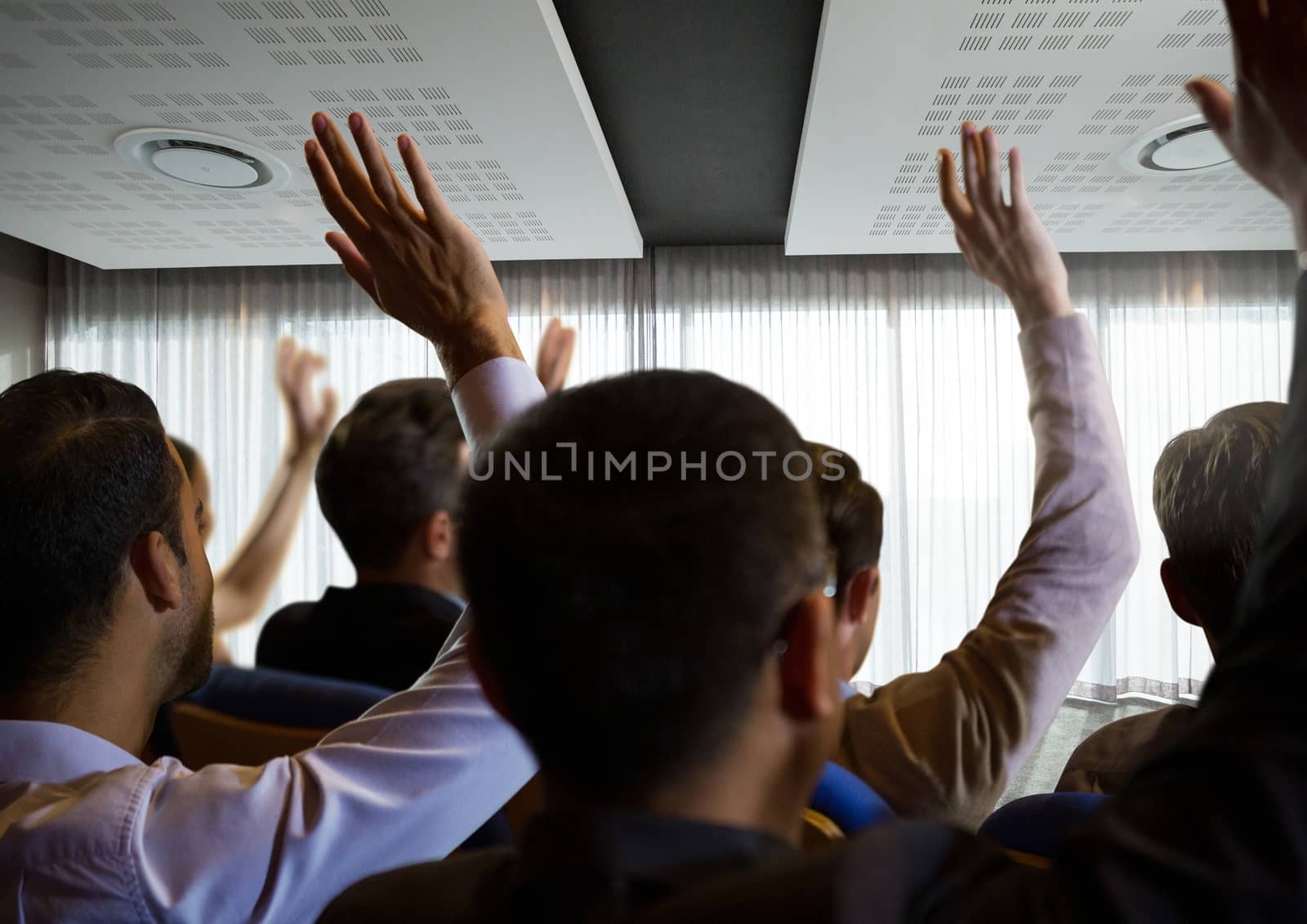Digital composite of Business people with raised hands up at conference by windows
