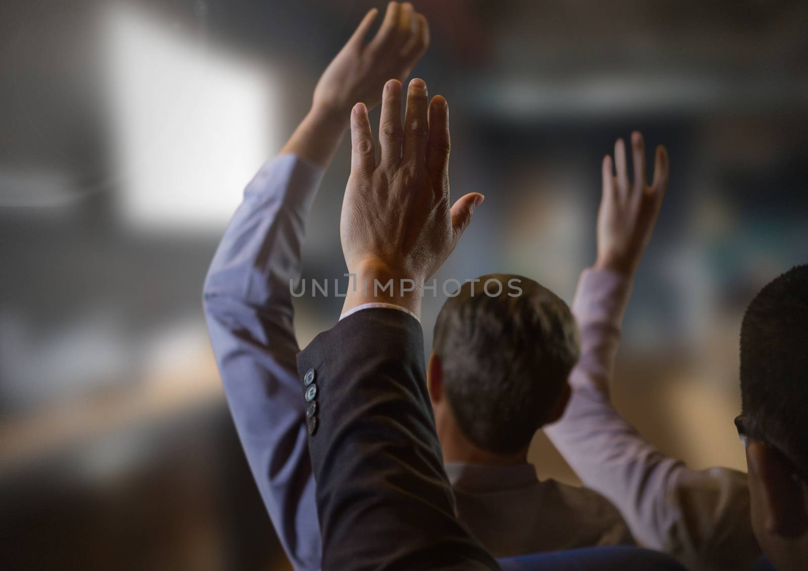 Digital composite of Business people with hands raised up at conference