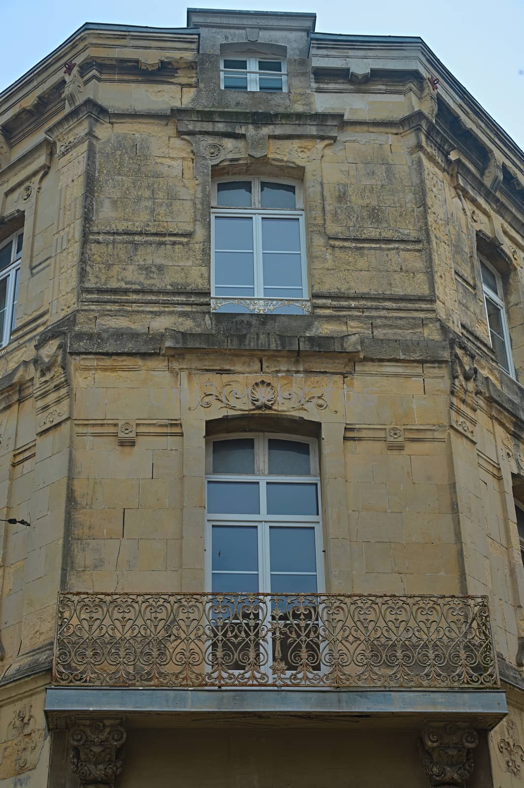 Old traditional French stone corner building with wooden windows by sheriffkule