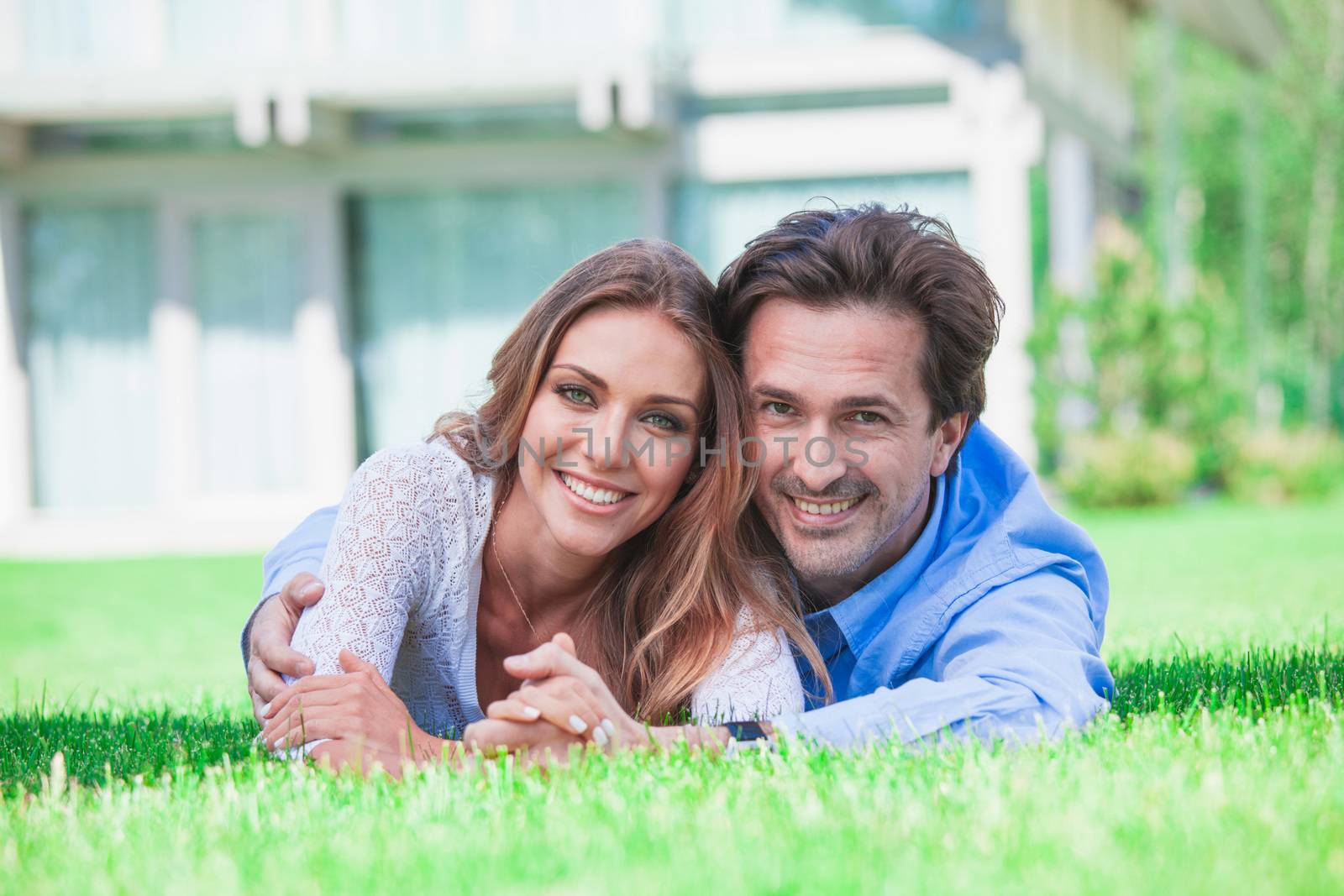 Couple laying in home garden by ALotOfPeople