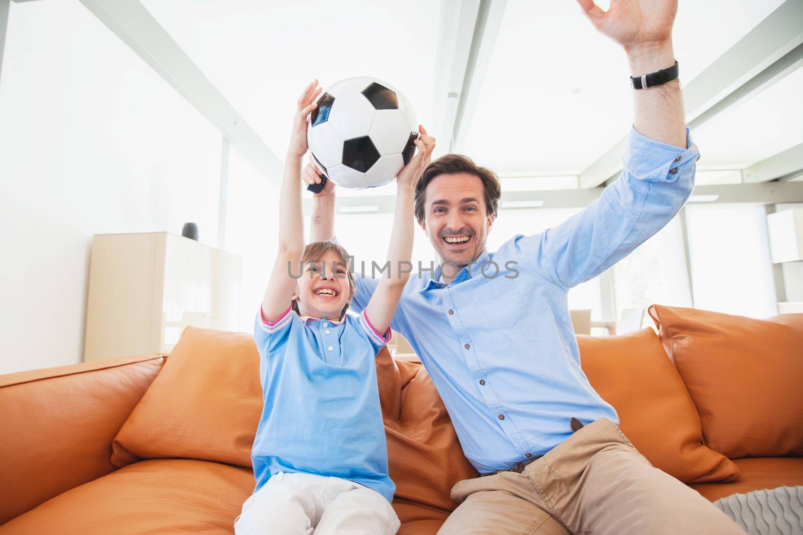 Father and son watching soccer by ALotOfPeople