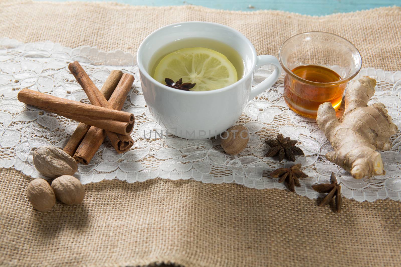 Ginger tea with honey and cinnamons on burlap by Wavebreakmedia
