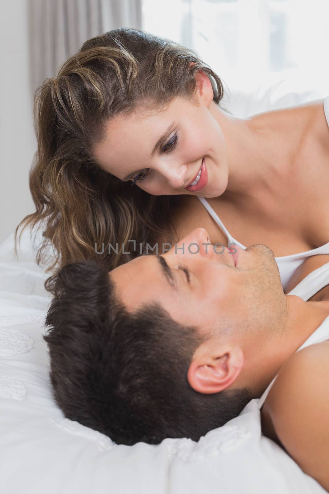 Couple lying in bed at home by Wavebreakmedia