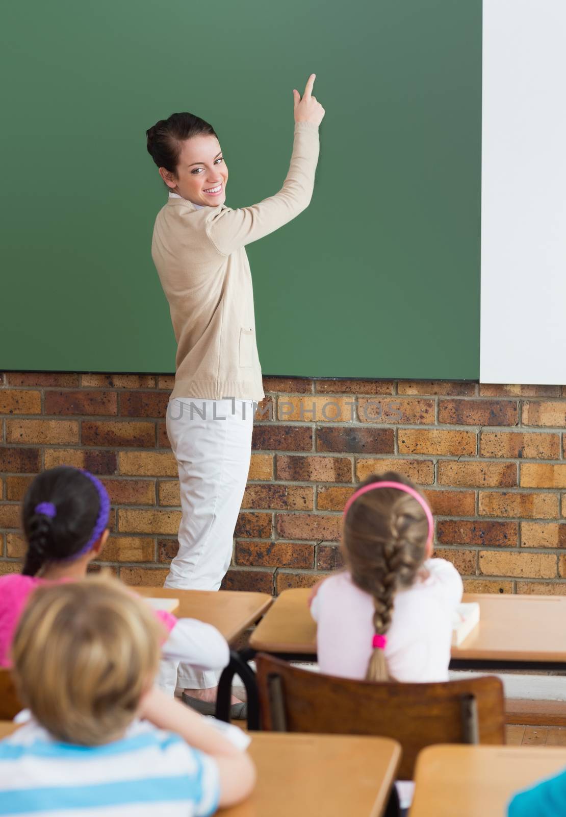 Cute pupils listening to their teacher in classroom at the elementary school