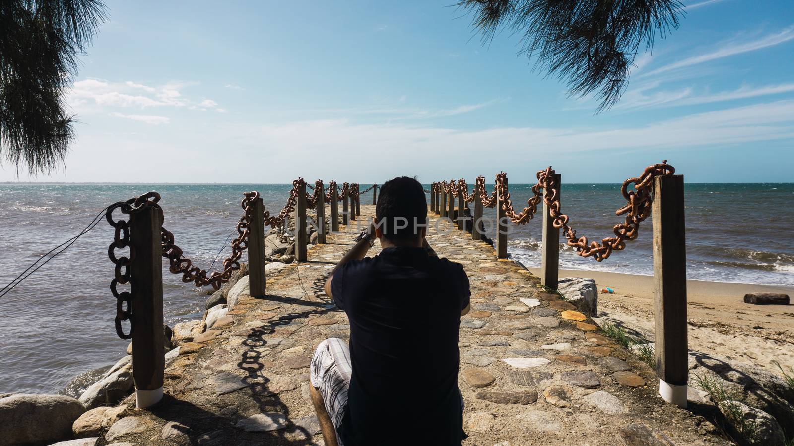 Photographer taking a photo on the pier with a pretty sea view by henrry08