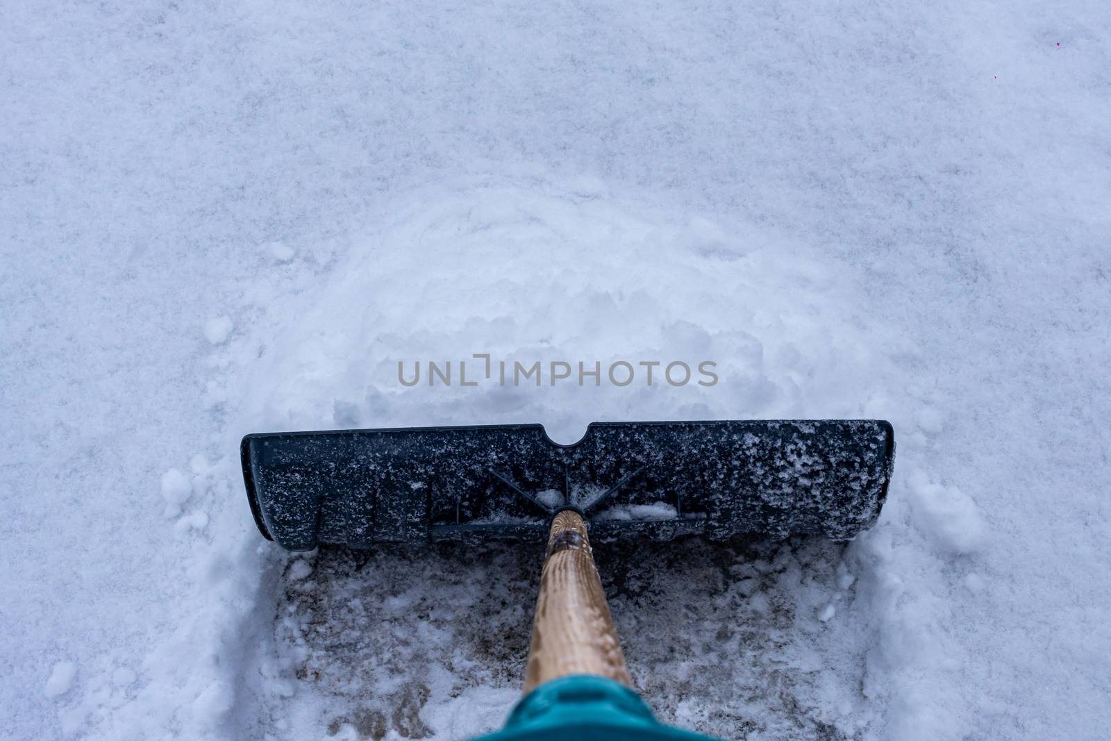 Shoveling snow in a winter driveway by colintemple