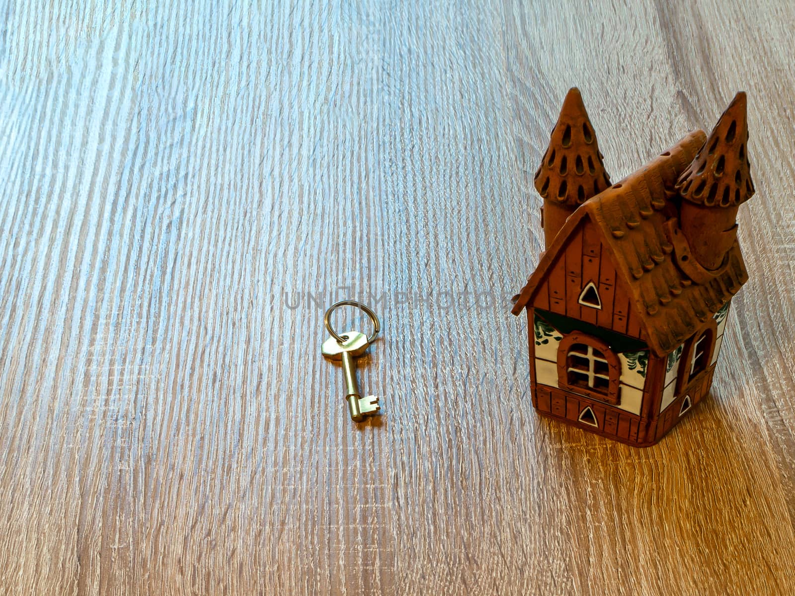 Model of a house and golden key On Wooden Table. Real estate agency, mortgage loan, lottery, buying property.Home loan and investment concept. Copy space