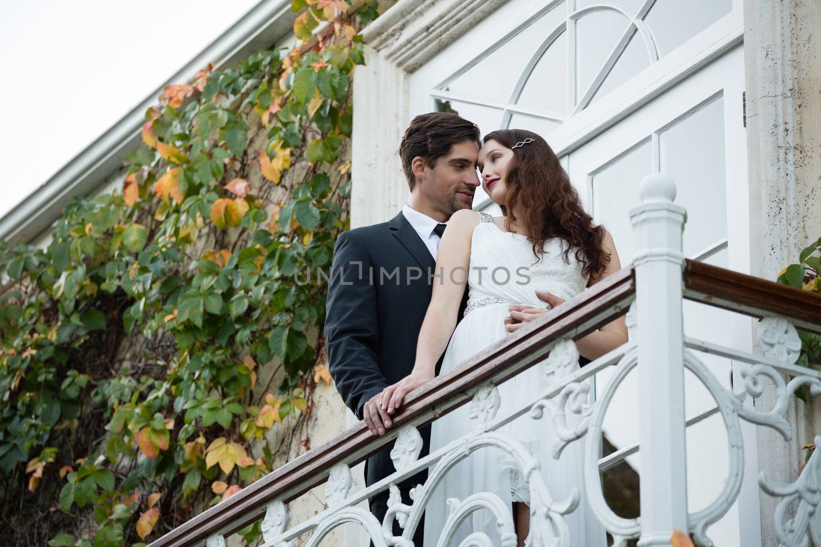 Low angle view of romantic couple looking at each other while standing in balcony