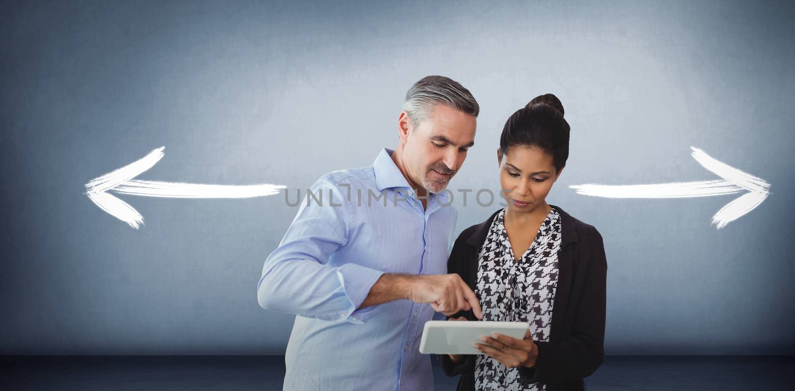 Portrait of business people using digital tablet  against grey room