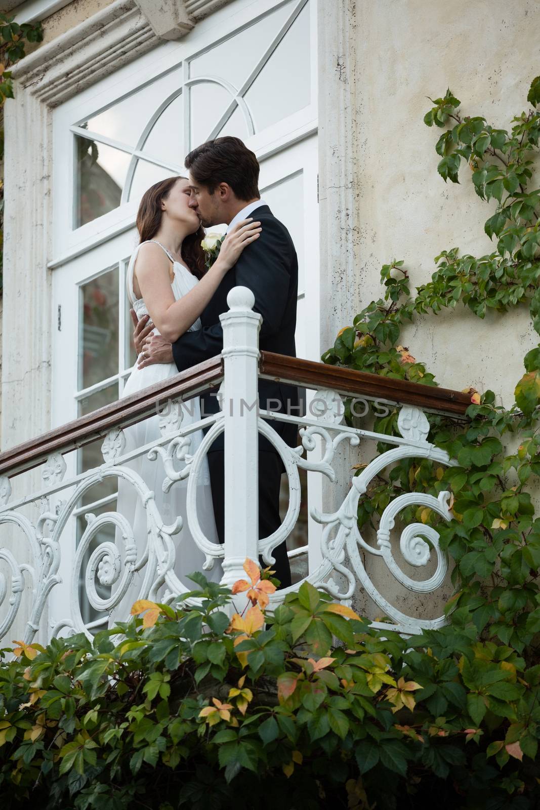 Low angle view of romantic couple kissing while standing in balcony