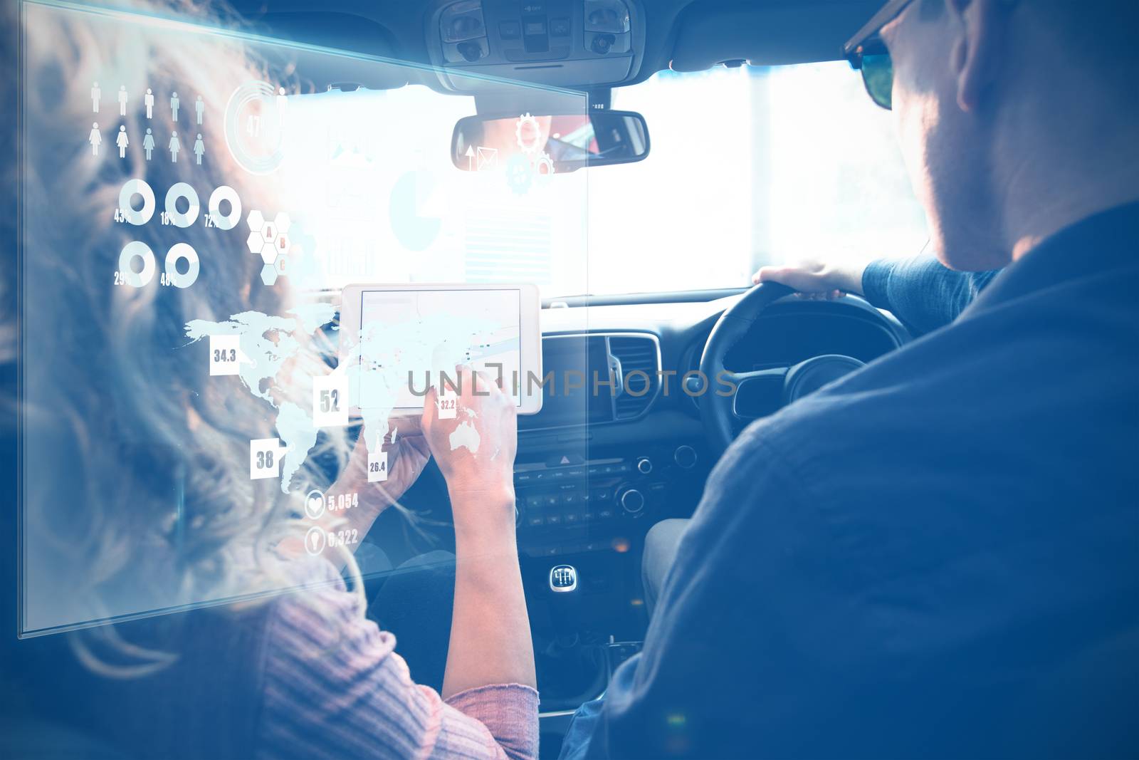 Global technology background against couple looking at tablet on a car