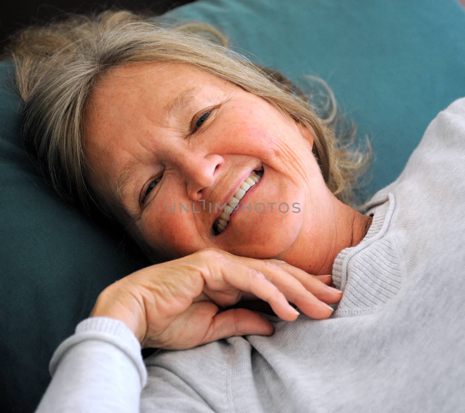 Mature female senior relaxing in bed.