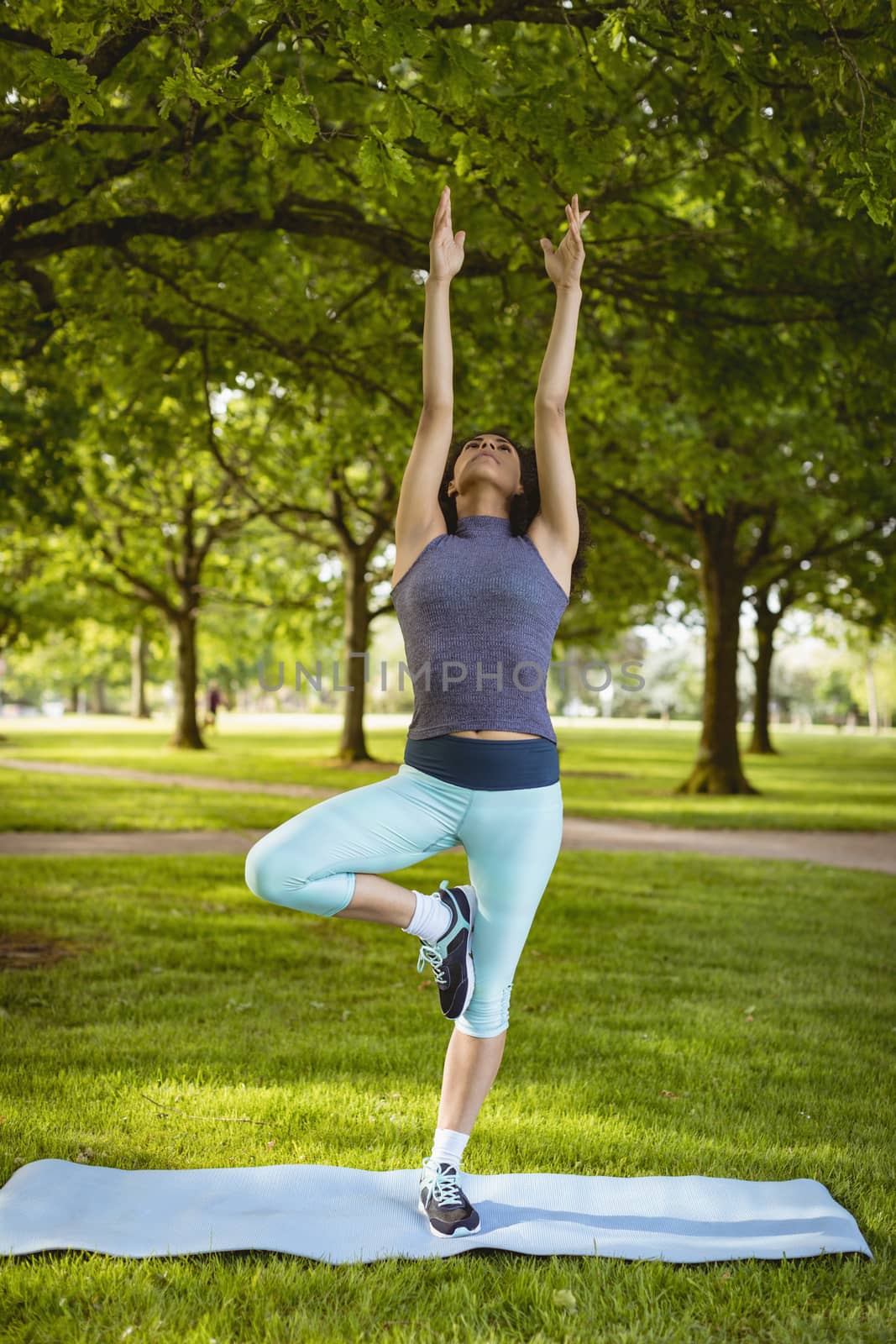 Woman performing yoga in the park by Wavebreakmedia