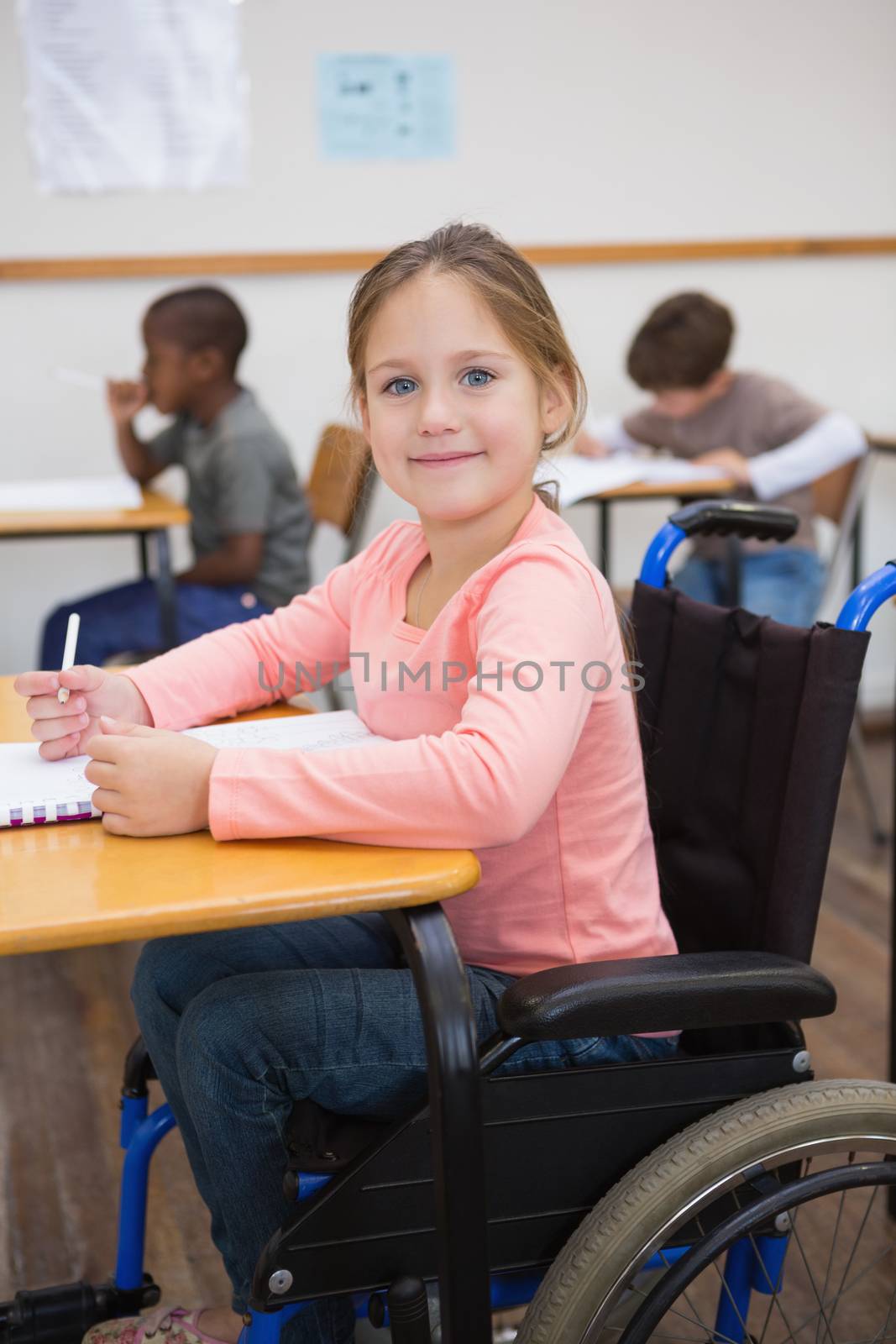 Disabled pupil smiling at camera in classroom at the elementary school