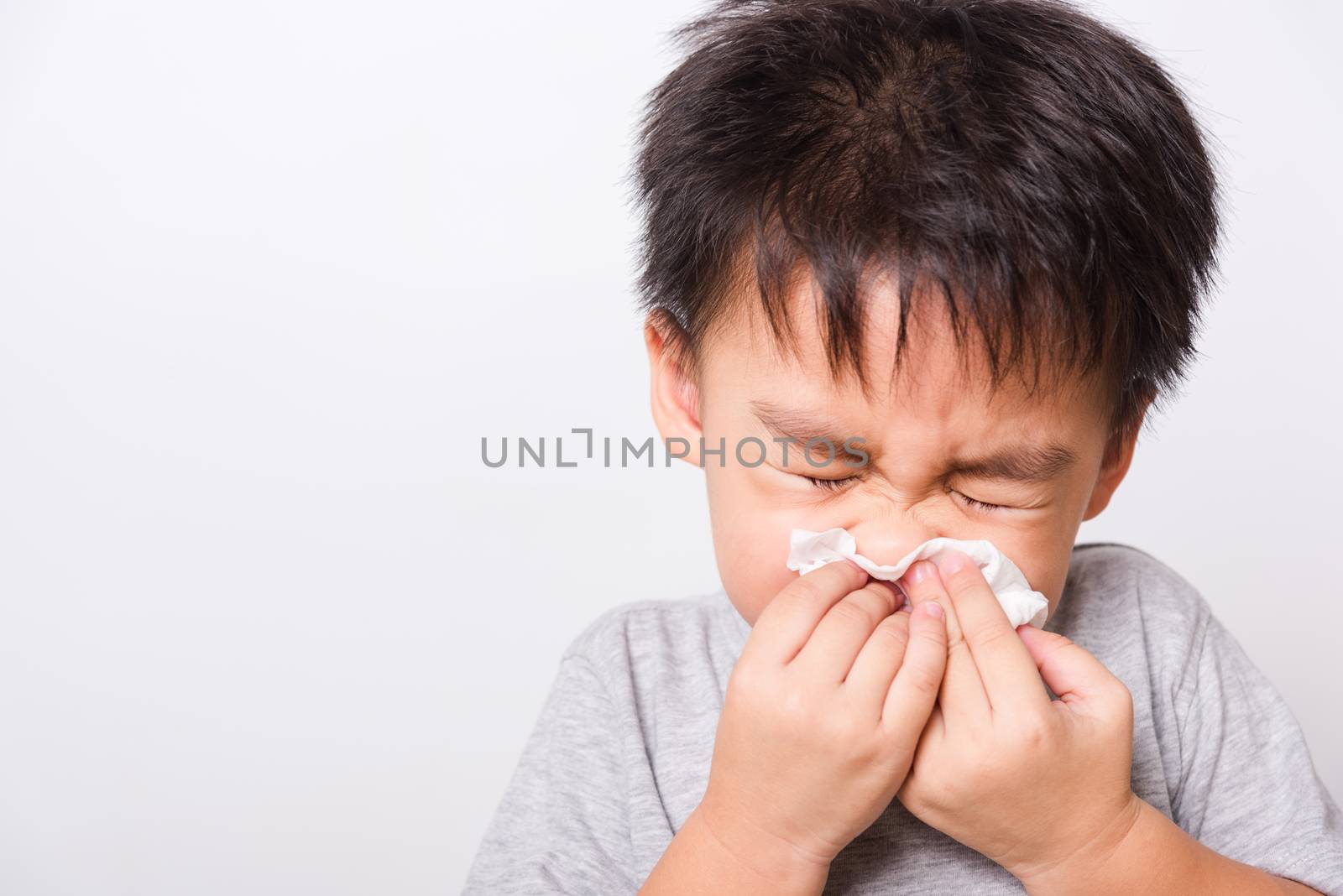 Closeup Asian face, Little children boy cleaning nose with tissu by Sorapop