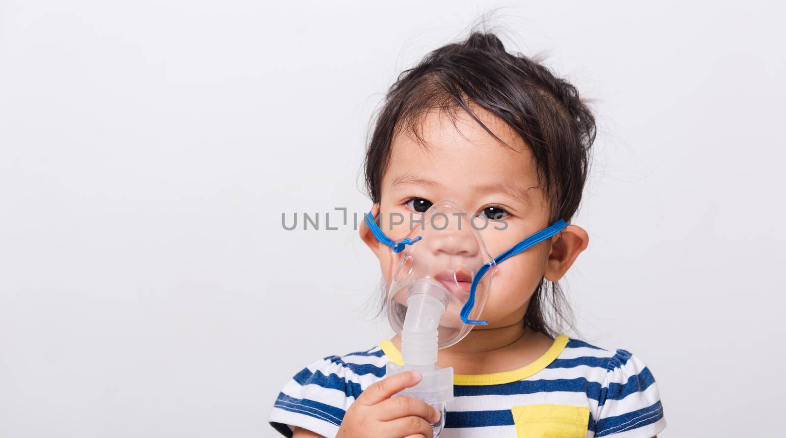 Closeup Asian face, Little baby girl sick her using steam inhaler nebulizer mask inhalation oneself on white background with copy space, health medical care